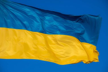 Rüzgarda savrulan Ukrayna bayrağı. Gökyüzünün arka planına karşı.