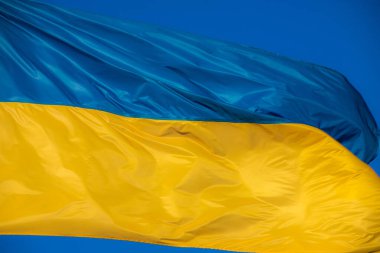 Rüzgarda savrulan Ukrayna bayrağı. Gökyüzünün arka planına karşı.