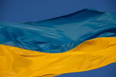 Rüzgarda savrulan Ukrayna bayrağı. Gökyüzünün arka planına karşı.