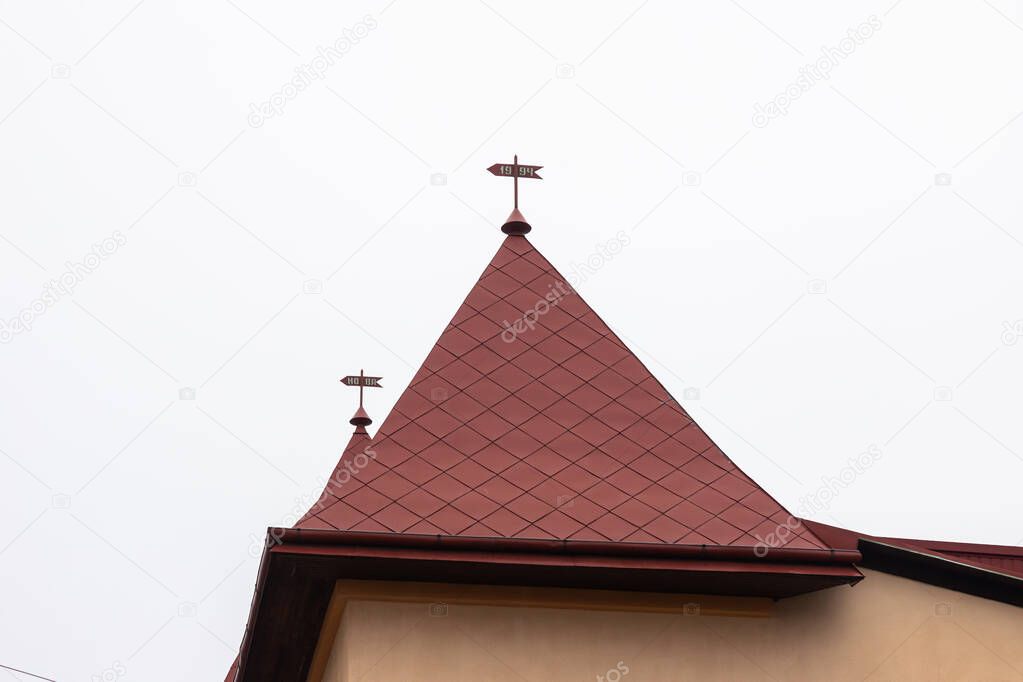 The roof of the house is made of red metal tiles, a beautiful large chimney.
