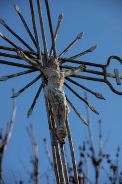 Bulutsuz gökyüzü arka planında haç olan eski metal haç. Dikey resim.