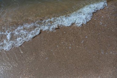 Kumsalda yaz güneşli deniz köpüğünün yakın çekimi..