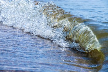 Sprey ve köpükle kıyıya yakın deniz dalgaları.