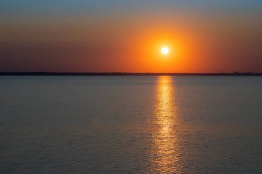 Gölün üzerinde güzel kırmızı ve orangutan gün batımı.