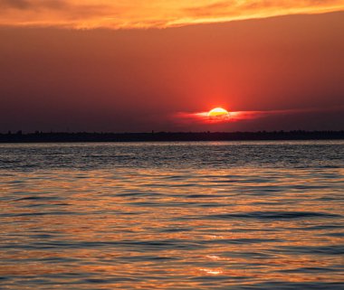 Gölün üzerinde güzel kırmızı ve orangutan gün batımı.