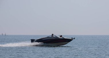 Küçük bir motorlu tekne denizin şok edici yüzeyinde yüzer..