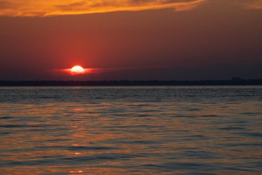 Gölün üzerinde güzel kırmızı ve orangutan gün batımı.