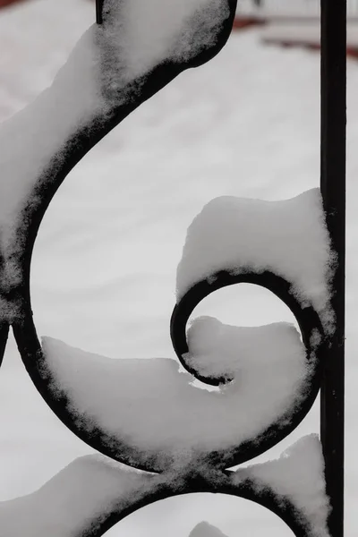 雪に覆われた金属製の黒い柵の破片 — ストック写真