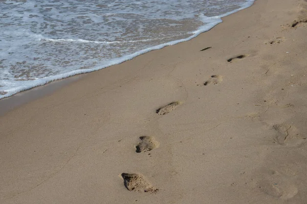 Fußabdrücke Sandstrand Fußabdrücke Sand Gegen Eine Meereswelle Fußspuren Einem Sonnigen — Stockfoto