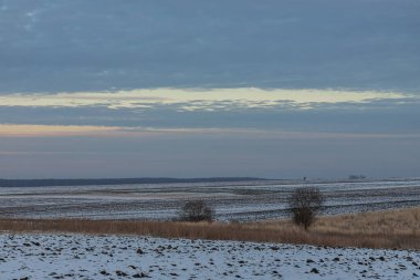 Saha ya da çayır üzerinde gün batımı. Kış karlı zemin üzerindeki gökyüzünün rengi. Gün batımında resim gibi bir gökyüzünün altındaki manzara. Güneşin doğuşu. Skyline, Horizon.