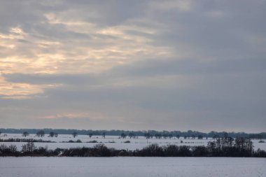 Saha ya da çayır üzerinde gün batımı. Kış karlı zemin üzerindeki gökyüzünün rengi. Gün batımında resim gibi bir gökyüzünün altındaki manzara. Güneşin doğuşu. Skyline, Horizon.