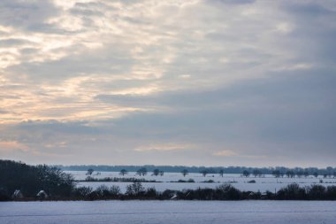 Saha ya da çayır üzerinde gün batımı. Kış karlı zemin üzerindeki gökyüzünün rengi. Gün batımında resim gibi bir gökyüzünün altındaki manzara. Güneşin doğuşu. Skyline, Horizon.