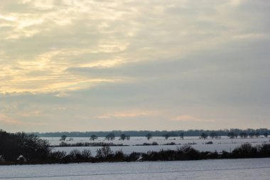 Saha ya da çayır üzerinde gün batımı. Kış karlı zemin üzerindeki gökyüzünün rengi. Gün batımında resim gibi bir gökyüzünün altındaki manzara. Güneşin doğuşu. Skyline, Horizon.