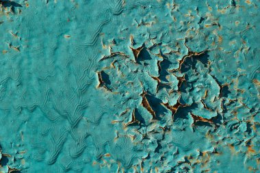 Duvardaki mavi kabuk boyası. Kırık boyalı eski beton duvar. Çatlaklar ve soyulma şekilleriyle eskimiş sert boyalı yüzey. Arkaplan ve tasarım için yüksek çözünürlüklü doku.