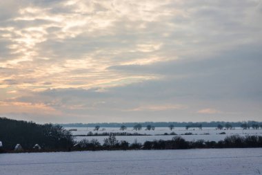 Saha ya da çayır üzerinde gün batımı. Kış karlı zemin üzerindeki gökyüzünün rengi. Gün batımında resim gibi bir gökyüzünün altındaki manzara. Güneşin doğuşu. Skyline, Horizon.