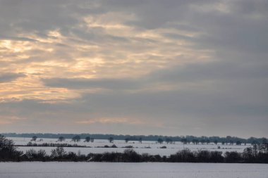 Saha ya da çayır üzerinde gün batımı. Kış karlı zemin üzerindeki gökyüzünün rengi. Gün batımında resim gibi bir gökyüzünün altındaki manzara. Güneşin doğuşu. Skyline, Horizon.
