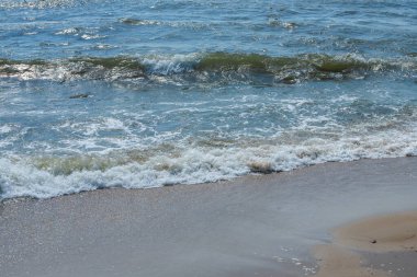 Sprey ve köpükle kıyıya yakın deniz dalgaları.