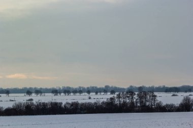 Saha ya da çayır üzerinde gün batımı. Kış karlı zemin üzerindeki gökyüzünün rengi. Gün batımında resim gibi bir gökyüzünün altındaki manzara. Güneşin doğuşu. Skyline, Horizon.