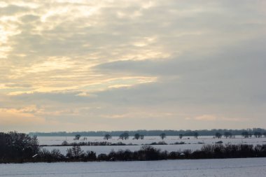 Saha ya da çayır üzerinde gün batımı. Kış karlı zemin üzerindeki gökyüzünün rengi. Gün batımında resim gibi bir gökyüzünün altındaki manzara. Güneşin doğuşu. Skyline, Horizon.