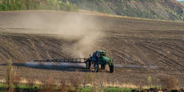 Traktör baharda sebze tarlasına böcek ilacı püskürtüyor..