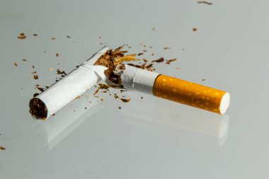 Hafif bir arka planda kırık sigara sineği. Sigara içmeyle mücadele kavramı.