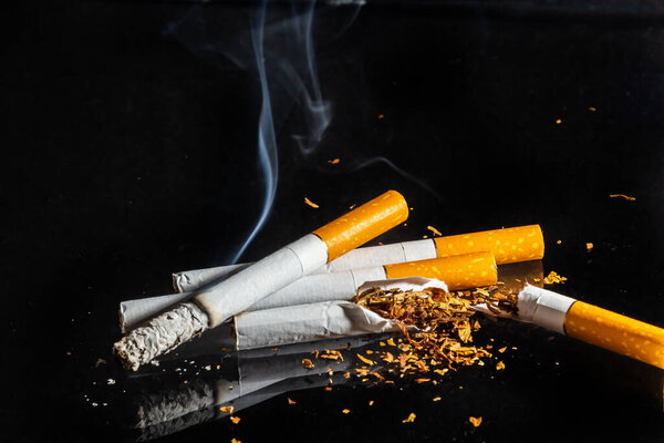 Курение сигарет крупным планом выделено на фоне бальзама. Не курить.