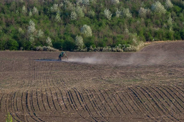トラクタースプレー肥料は 緑のフィールド 農業の背景概念に農薬を噴霧 — ストック写真
