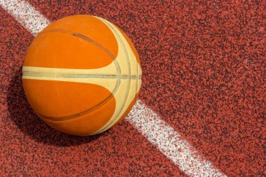 Turuncu top spor sahasında yatıyor. Kırmızı kort açık havada. Anlaşıldı..