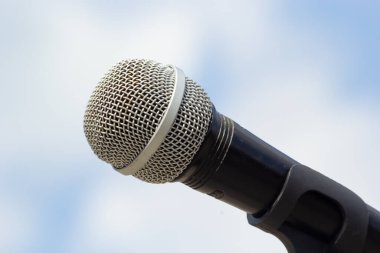 Gökyüzü arka planında mikrofon. Mikrofon caddede duruyor. Konsept - sokak müziği. Ses ekipmanı.