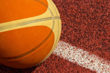 Turuncu top spor sahasında yatıyor. Kırmızı kort açık havada. Anlaşıldı..