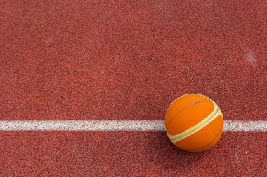 Turuncu top spor sahasında yatıyor. Kırmızı kort açık havada. Anlaşıldı..