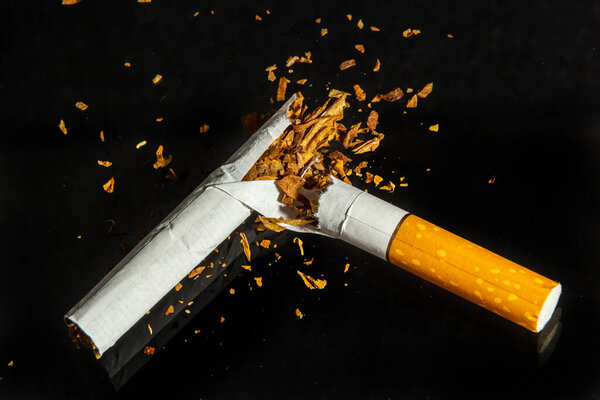 Всемирный день без табака, сломанная сигарета на черном фоне. Не курить
.