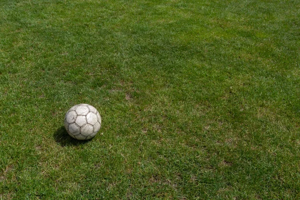 Soccer ball on green grass of football field with copy space.