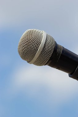 Gökyüzü arka planında mikrofon. Mikrofon caddede duruyor. Konsept - sokak müziği. Ses ekipmanı.