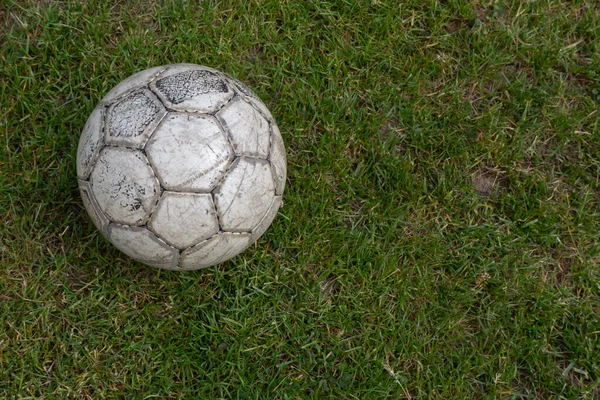 Soccer ball on green grass of football field with copy space.