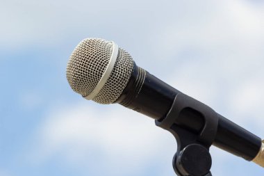 Gökyüzü arka planında mikrofon. Mikrofon caddede duruyor. Konsept - sokak müziği. Ses ekipmanı.