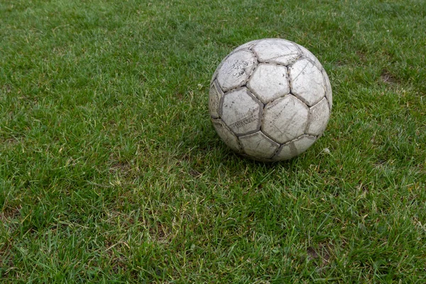 Soccer ball on green grass of football field with copy space.