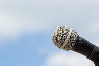 Gökyüzü arka planında mikrofon. Mikrofon caddede duruyor. Konsept - sokak müziği. Ses ekipmanı.