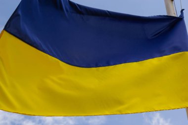 Rüzgar ve güneş ışığında dalgalanan Ukrayna bayrağı. Mavi gökyüzü arka planında Ukrayna bayrağı. Ulusal özgürlük ve bağımsızlık sembolü.