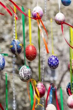 Boyalı yumurtalar Paskalya ağacının dallarına asılır. Odak noktası, çocuklar tarafından elle boyanmış sarı bir yumurta. Yüksek kalite fotoğraf