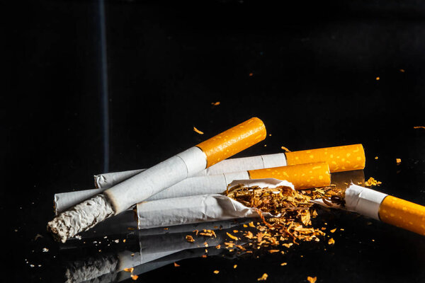Курение сигарет крупным планом выделено на фоне бальзама. Не курить.