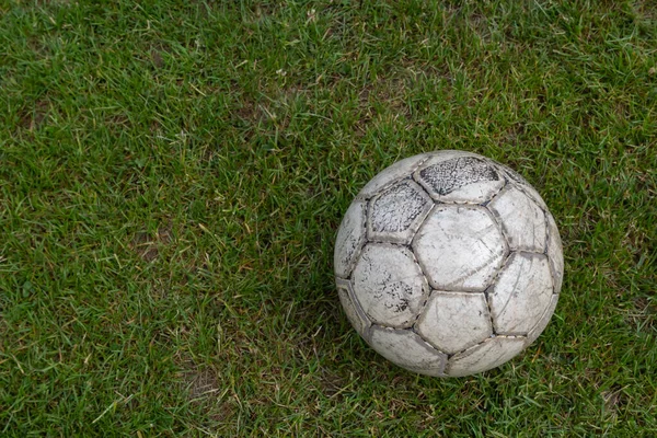 Soccer ball on green grass of football field with copy space.