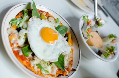 Pizza taze yumurta ve fesleğen yaprakları ile