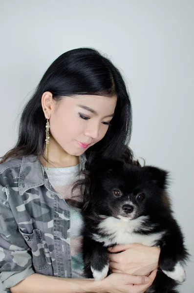 Asian girl with black pommeranian puppy — Stock Photo, Image