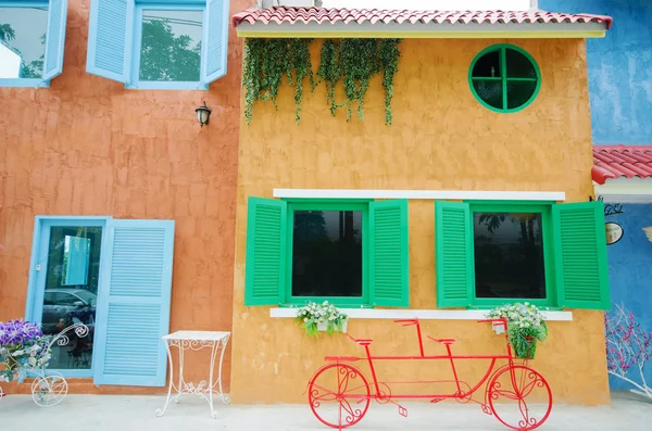 Bicicleta vermelha na frente do fundo do edifício colorido — Fotografia de Stock