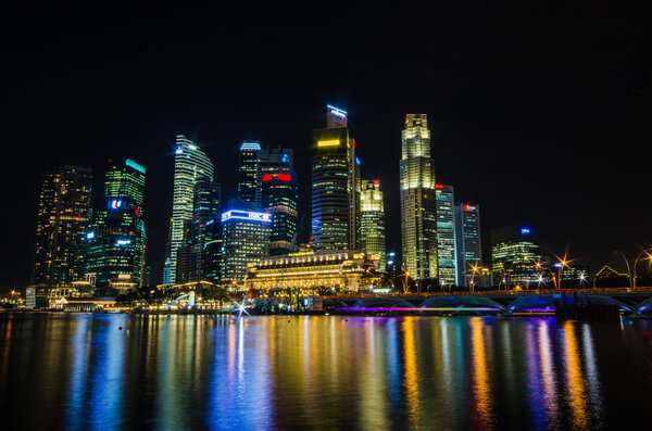 Singapore city skyline view of business district in the night time, with beautiful water reflections.