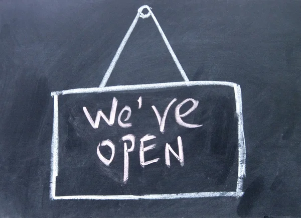 we are open sign drawn with chalk on blackboard