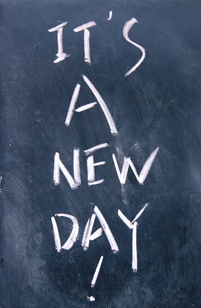 It is a new day title written with chalk on blackboard — Stock Photo, Image