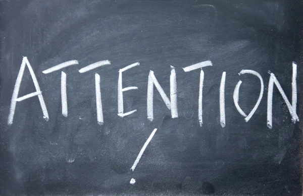 Attention title written with chalk on blackboard — Stock Photo, Image