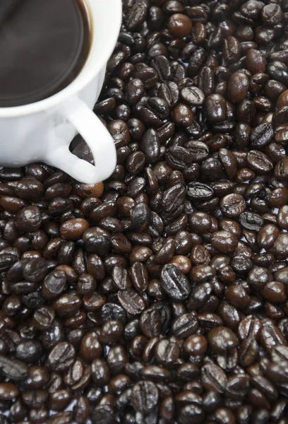 Šálek kávy a kávové zrna pozadí — Stock fotografie